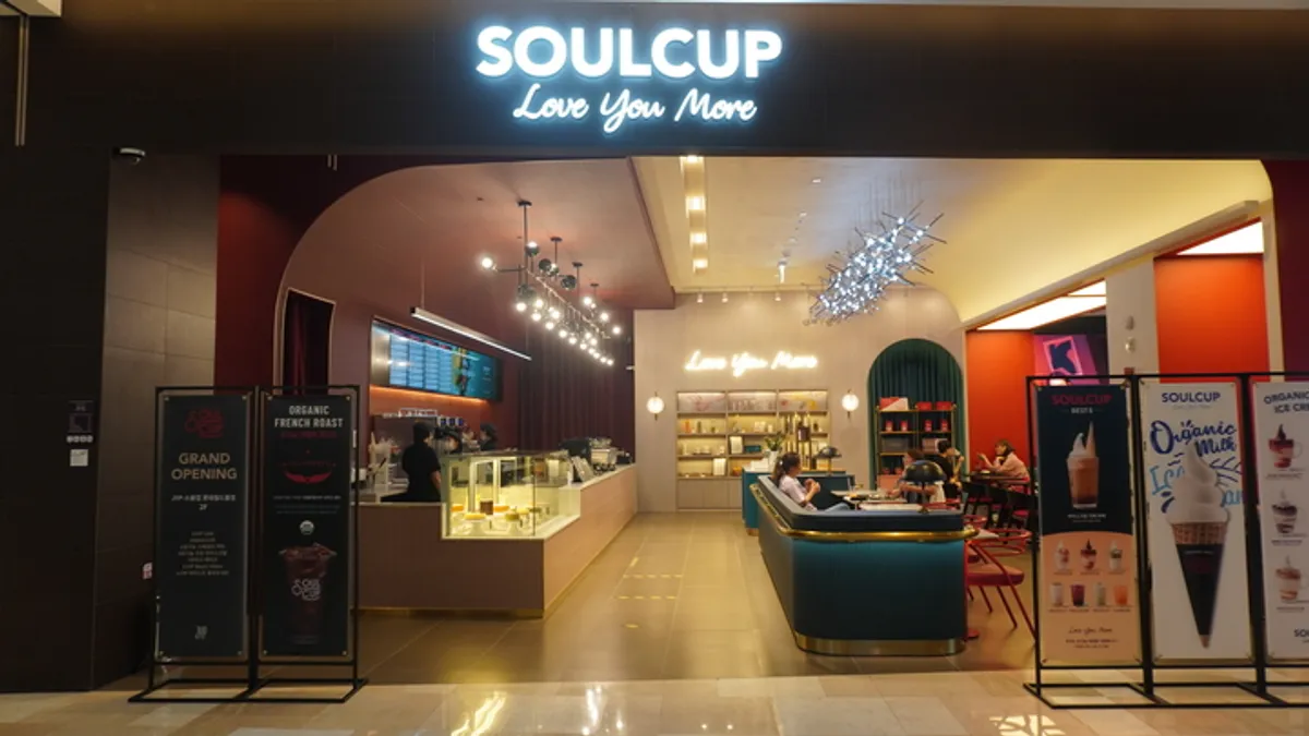 บรรยากาศร้านกาแฟ JYP Soul Cup ที่จัมซิลในกรุงโซล พร้อมคำว่า Love You More เหนือเคาน์เตอร์