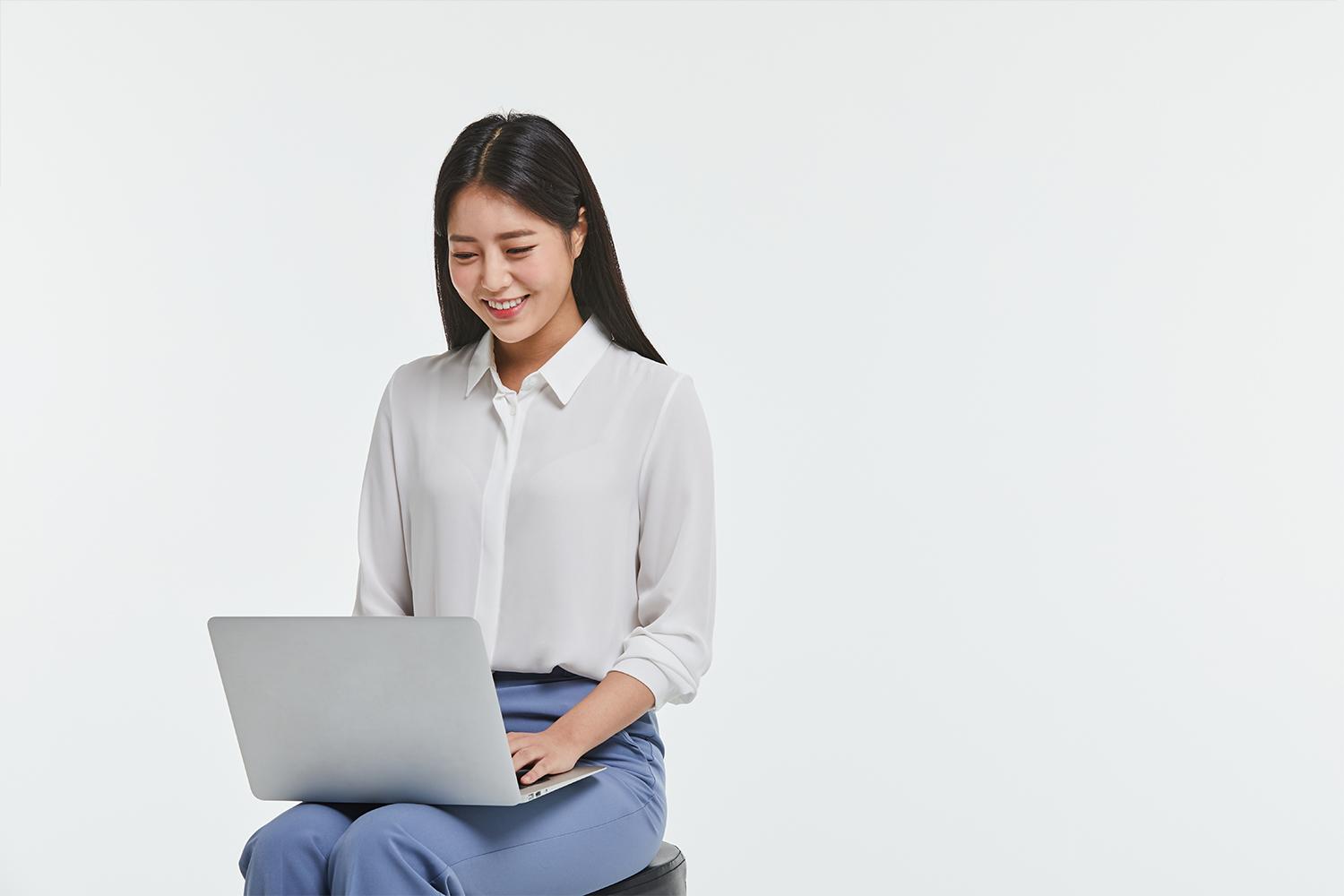 woman on a stool with a laptop open 