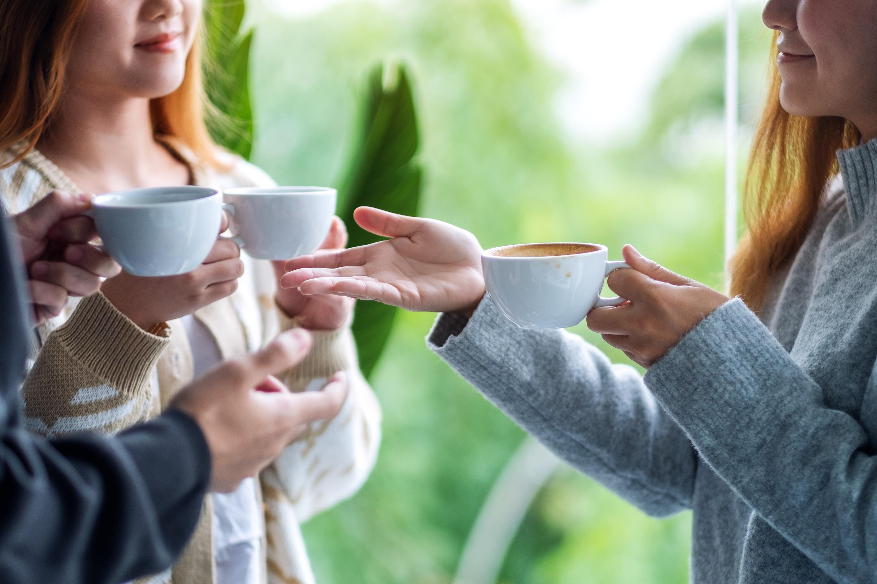 コーヒーカップを持って交流する様子。韓国の人々のコミュニケーション文化を示す画像。