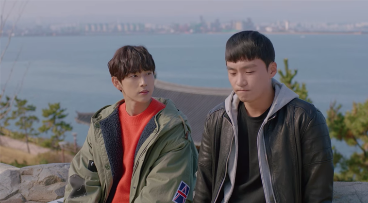 兩位角色坐在延烏郎細烏女主題公園的石牆上，背景為海景，場景出自《Run On奔向愛情》。