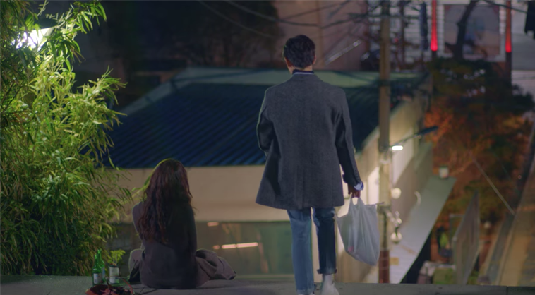 一位角色在浦項九龍浦日本人家屋街走下階梯，地面上有酒瓶，這是韓劇《Run On奔向愛情》的場景。