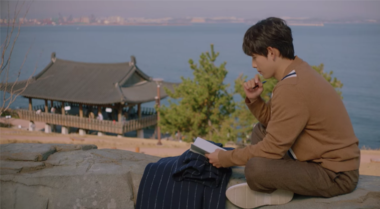 一位坐在石頭上看海景的角色，拍攝於延烏郎細烏女主題公園，該地點因《Run On奔向愛情》而聞名。