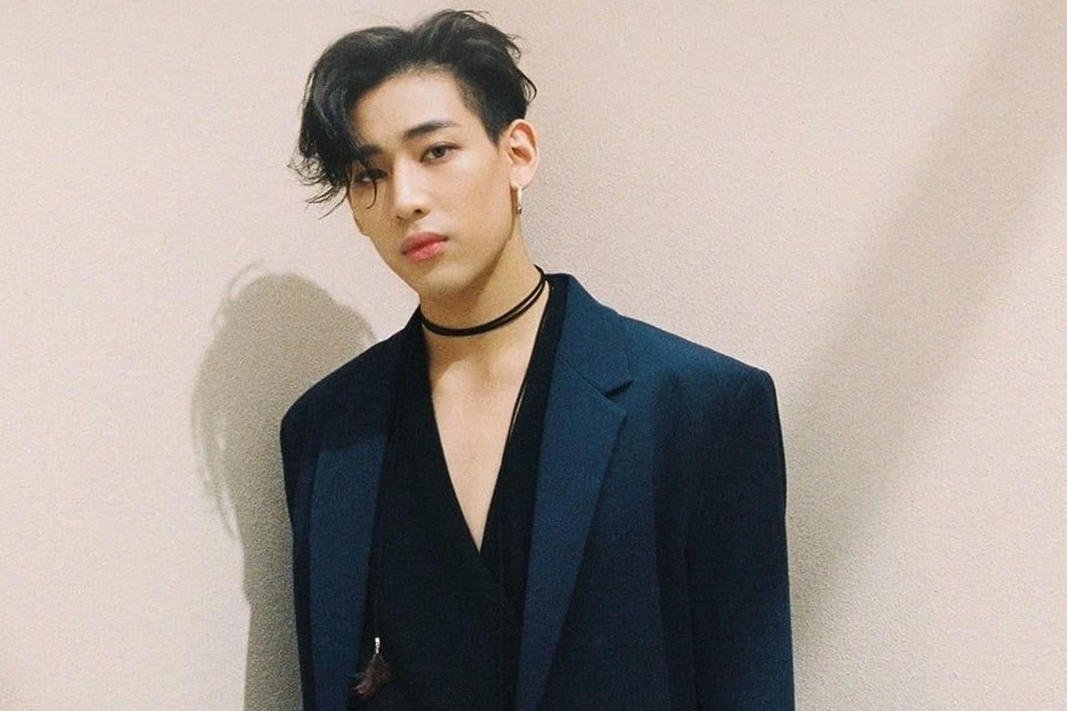 GOT7 멤버 중 한 명이 검은색 의상과 액세서리를 착용하고 있음