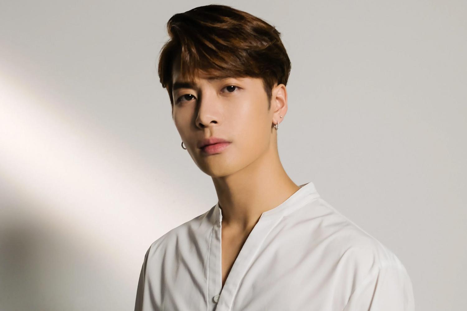 GOT7 멤버 중 한 명이 흰색 셔츠를 입고 서 있는 모습