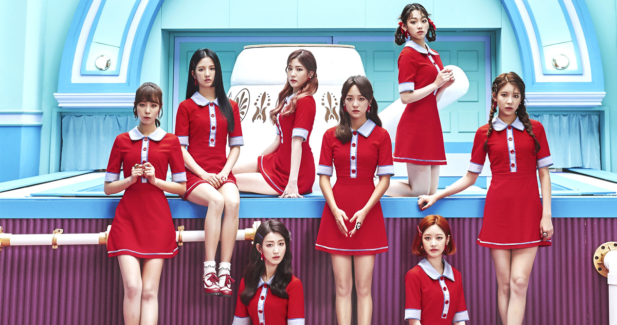 gugudan 女團成員穿著紅色制服，在色彩豐富的背景下擺出造型。