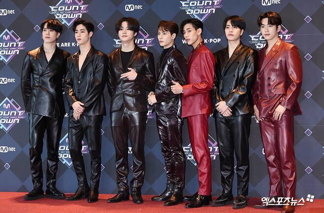 GOT7メンバーがMnet Countdownのレッドカーペットで黒と赤のスーツを着て並んでいる姿。