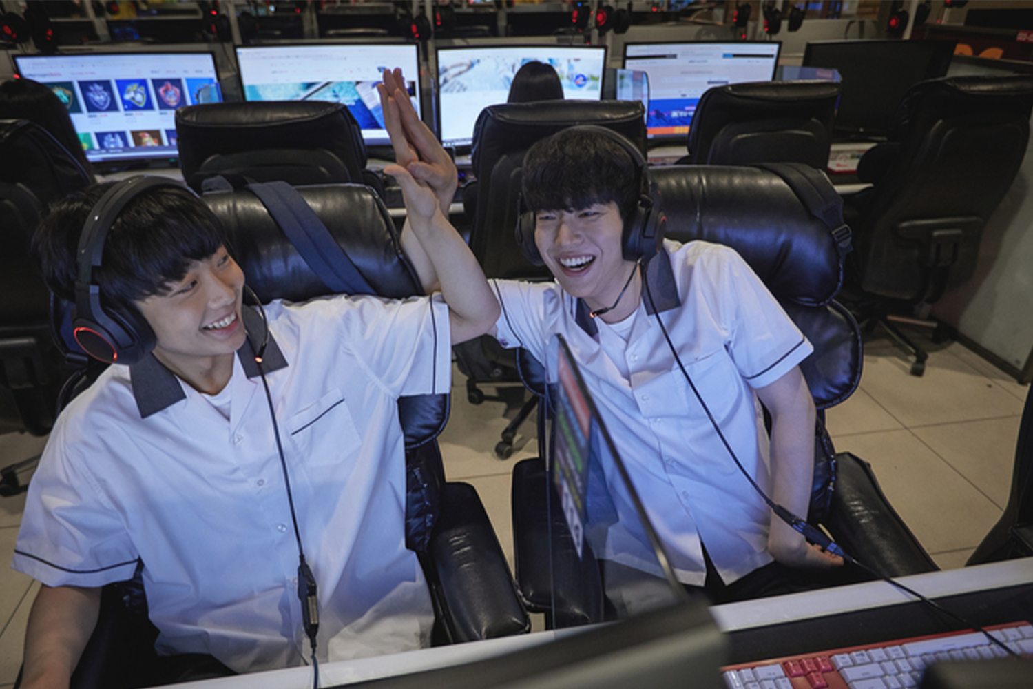 在韓國網吧玩遊戲的青少年，背景是一排電腦螢幕，營造出演戲的氛圍。