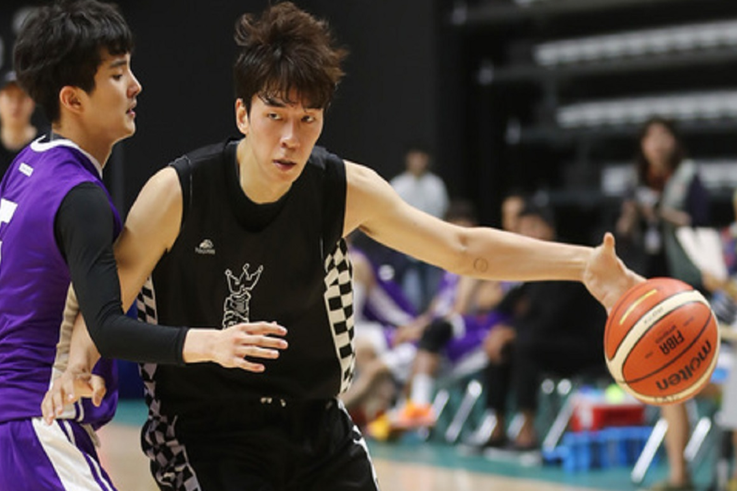 籃球運動員在比賽中運球的動態畫面，顯示出運動技巧和速度。