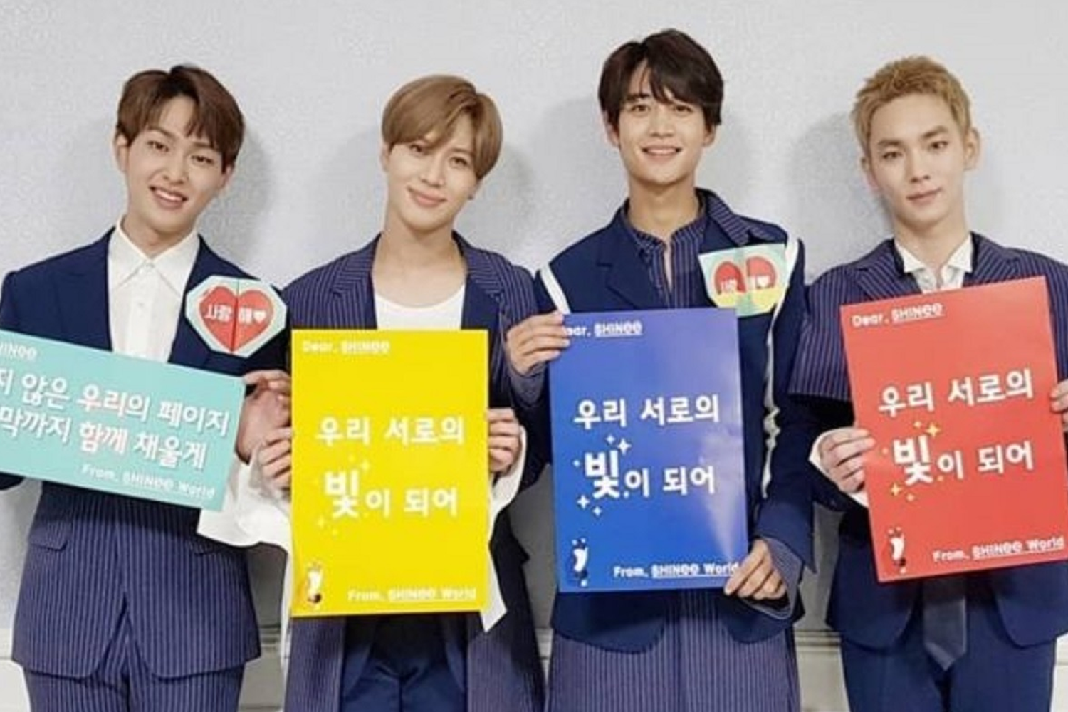 SHINee成員們在粉絲見面會上，手持板畫展示成員間的默契和團結。