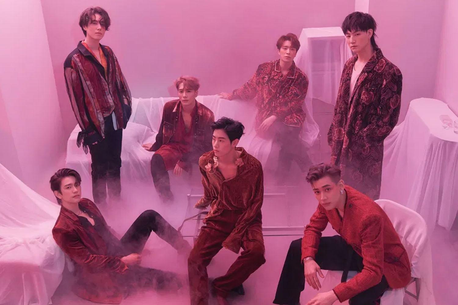 ภาพถ่ายของสมาชิกวง GOT7 ในห้องที่มีแสงสีชมพู สมาชิกทุกคนแต่งกายอย่างหรูหราและมีบรรยากาศโรแมนติก