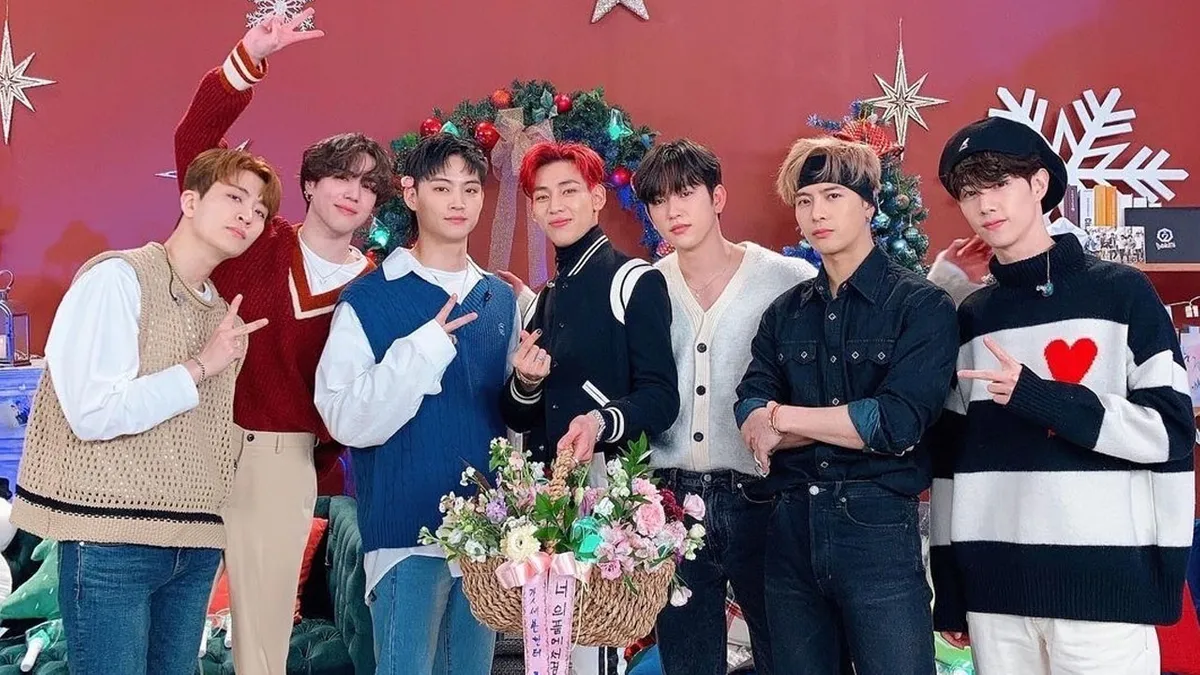 สมาชิกวง GOT7 ถ่ายรูปร่วมกันในชุดเสื้อกันหนาวและรองเท้าบู๊ท พร้อมด้วยของประดับคริสต์มาส