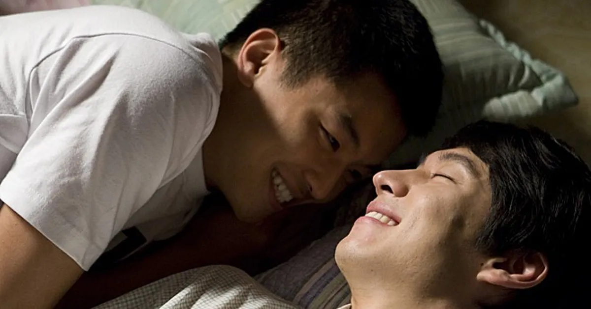 兩位男生仰卧在牀上，顯示親密關係。