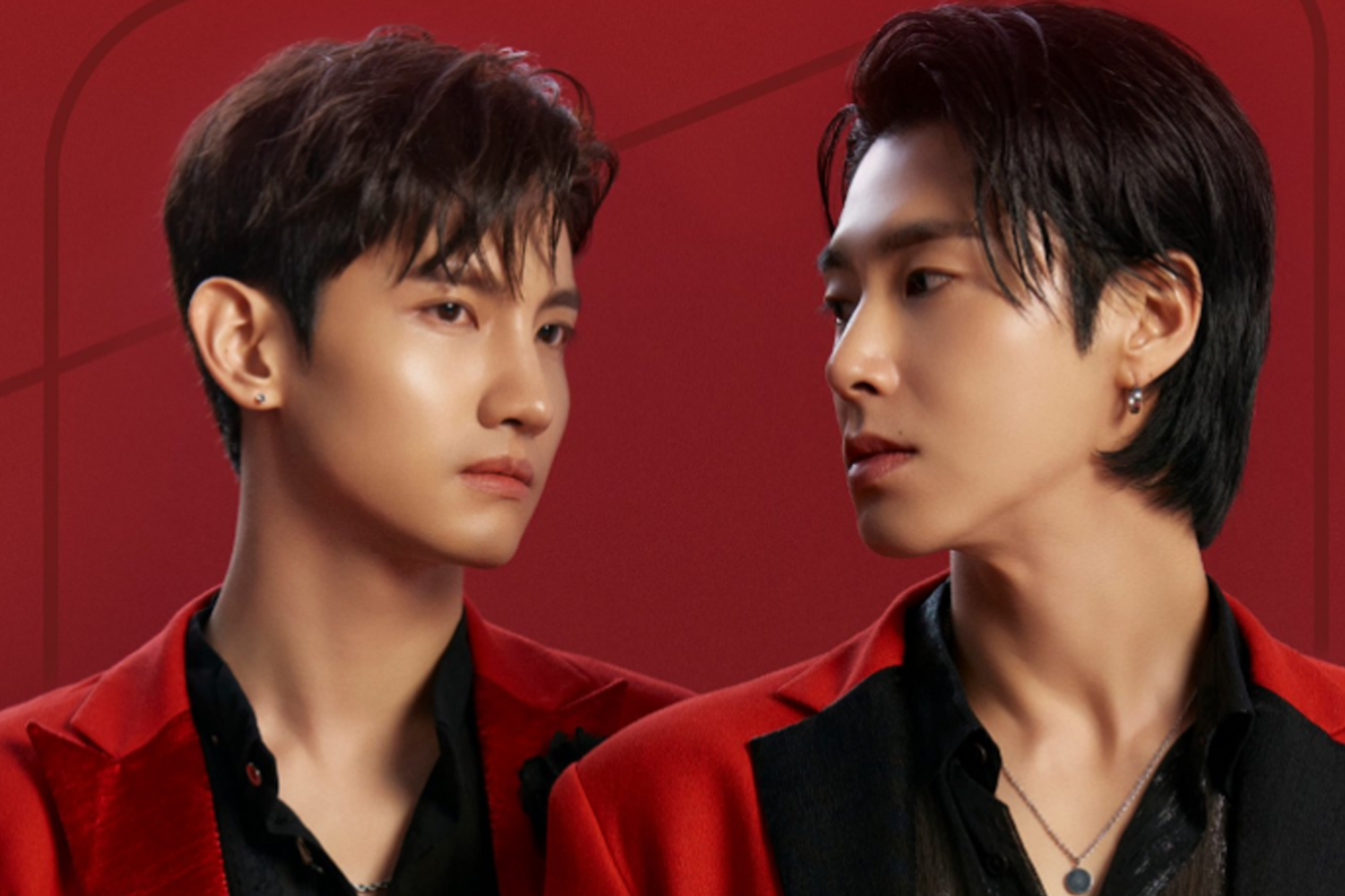 兩位男団 成員，身穿紅色西裝，黑色襯衫，站在紅色背景前，相互對視，展現冷峻的形象。