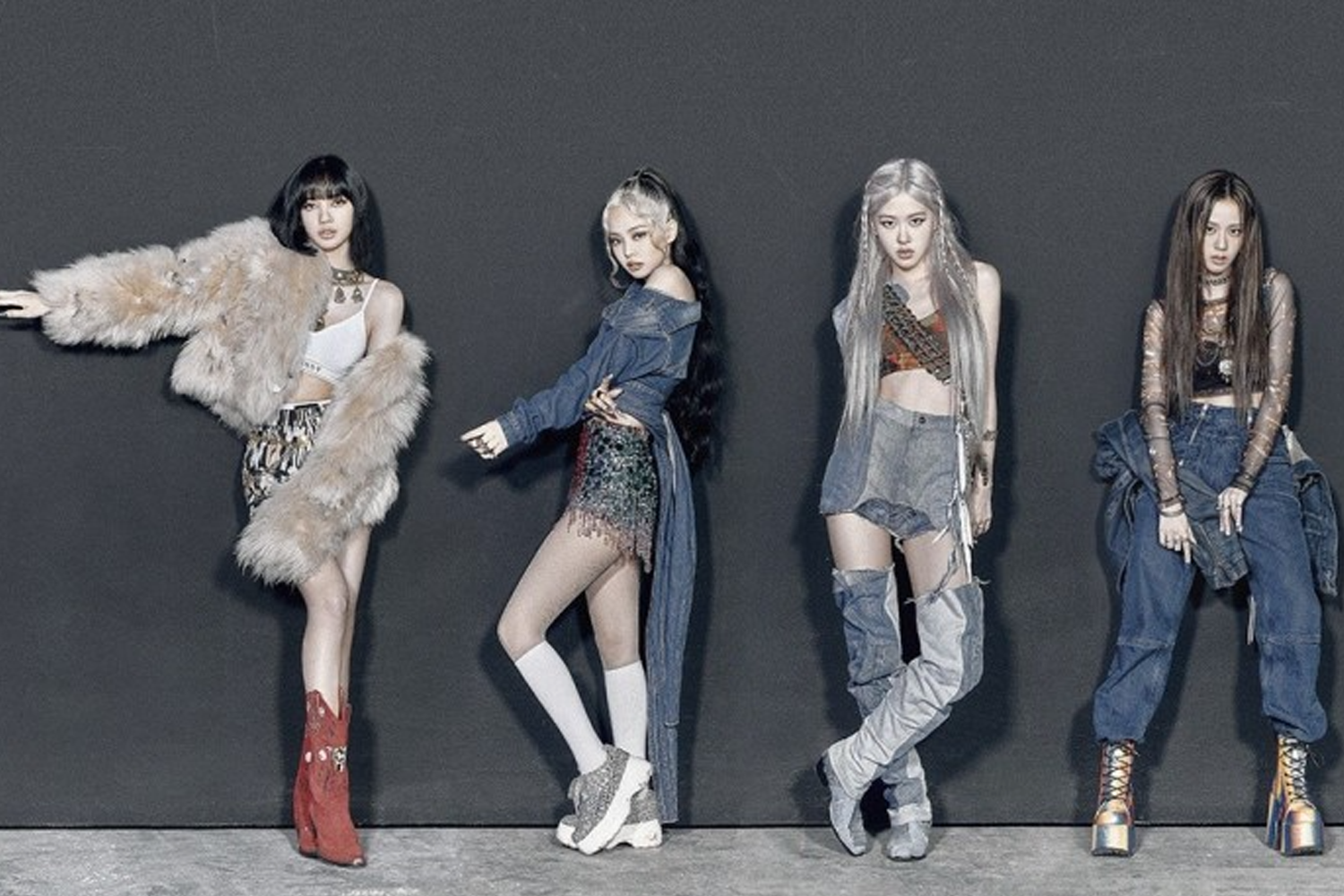 四位女團成員站成一排，身穿各種時尚服裝，背景為黑色牆面，該團體以強勁音樂風格著稱。