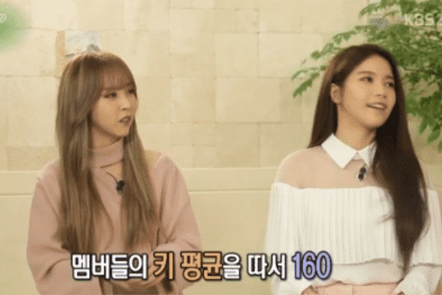 兩位女性坐在室內，背景設計為米色大理石牆面，左下顯示韓文字體，她們的穿著配色沉穩且典雅。