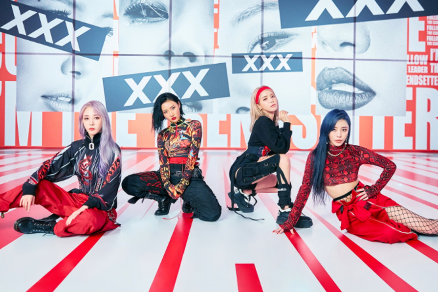 四名女團成員在橙色舖地背景前，穿著紅色系演出服，有著強烈的視覺衝擊感，配合歌曲的表演場景。