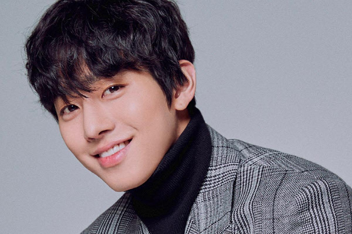 韓國演員安孝燮穿著休閒長袖上衣，坐在户外平台，背景為藍天。