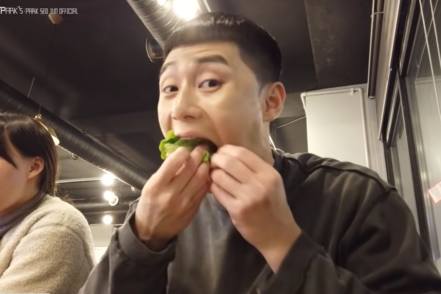 韩国餐厅中桌上的韩国包饭料理，配有丰富的辣酱、小菜和生菜，体现了包饭作为韩国饮食文化的重要组成部分。