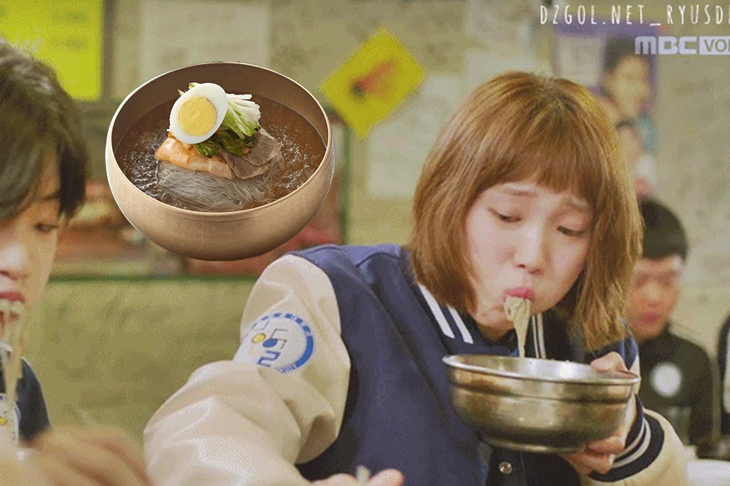คำบรรยายภาพ: บะหมี่เย็นหรือแนงมยอนในชามทองเหลืองเกาหลี พร้อมกับนักแสดงในชุดเครื่องแบบโรงเรียนจากซีรีส์เกาหลี แสดงให้เห็นถึงวิธีการเสิร์ฟอาหารนี้ในช่วงฤดูหนาว ซึ่งเป็นที่นิยมอย่างมากในเกาหลี