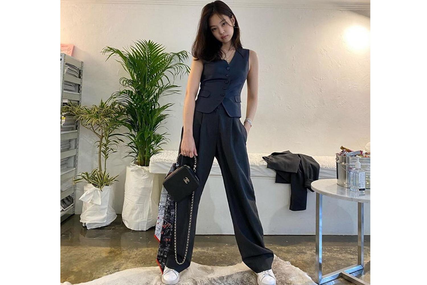 黑色無袖西裝外套配闊腿長褲,典雅俐落,分別搭配黑色包包與白色運動鞋,強調身材比例。