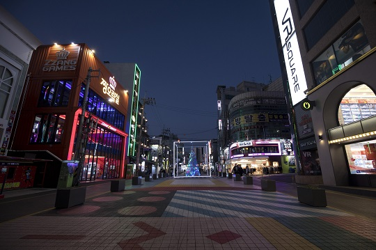 香港夜街景，配有鮮豔霓虹燈光，各行業正遵循防疫措施逐步恢復營業。