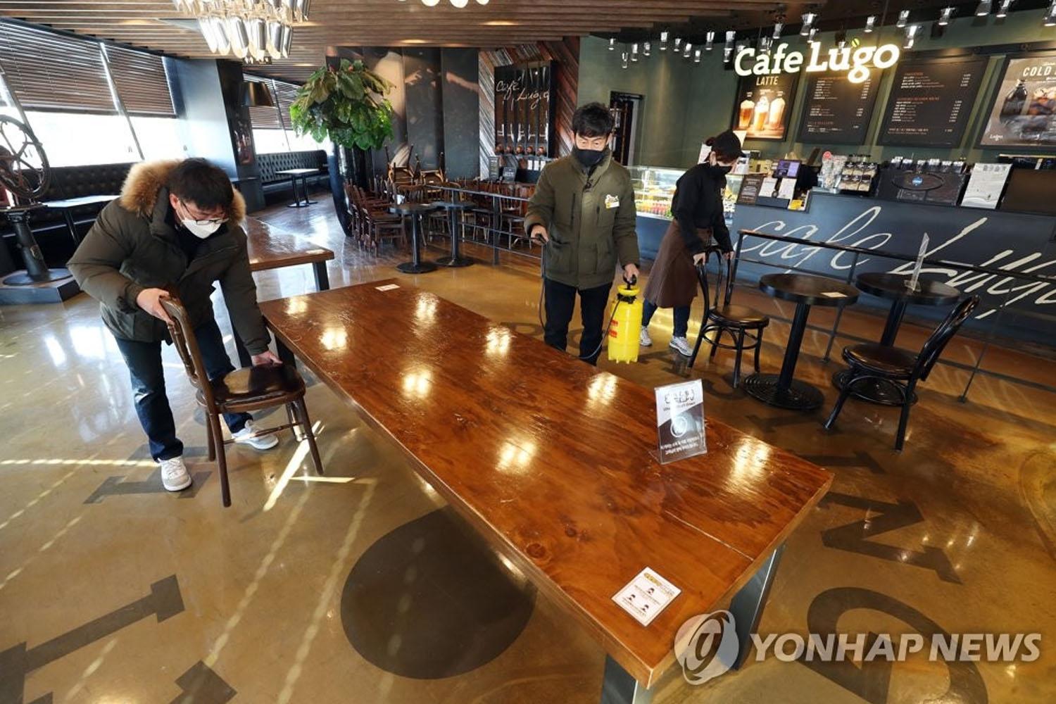 พนักงานทำความสะอาดภายในร้านกาแฟประเทศเกาหลีใต้ ภายใต้มาตรการป้องกันโควิด-19