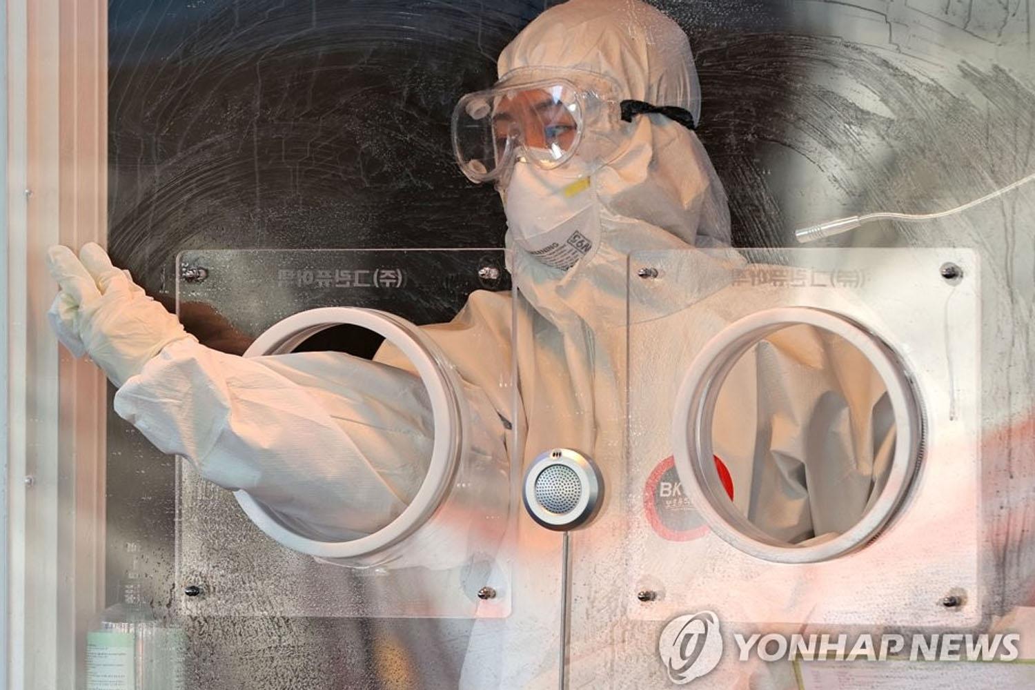 เจ้าหน้าที่สาธารณสุขสวมชุดป้องกันขณะทำงานในสถานที่ตรวจโรคโควิด-19 ประเทศเกาหลีใต้