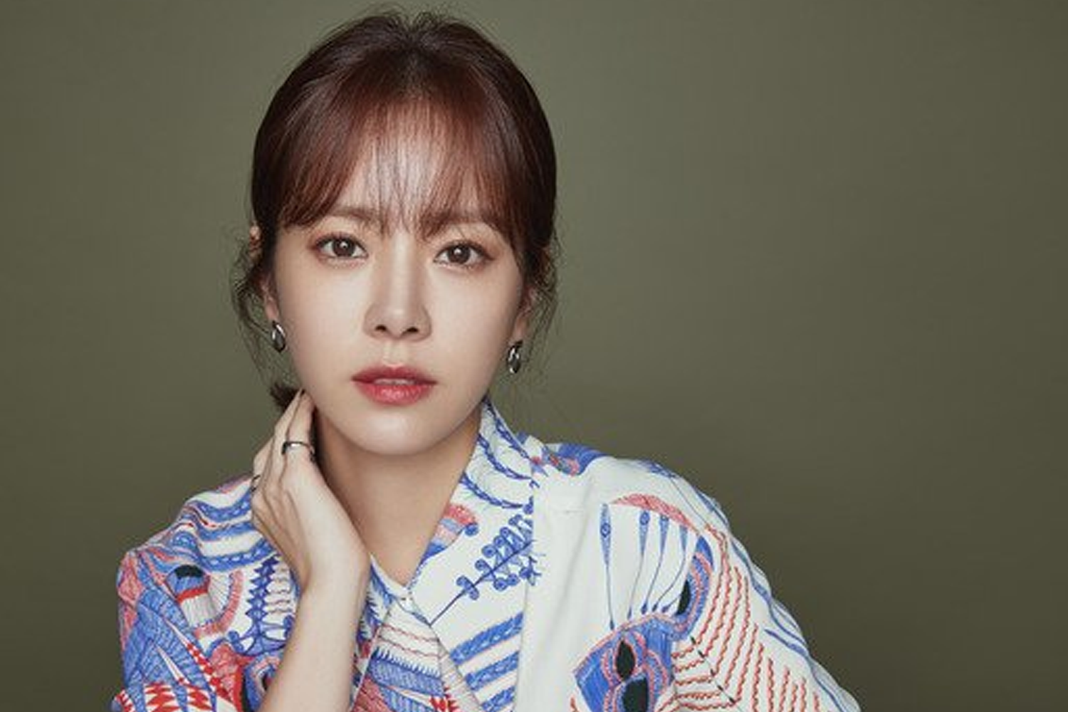 韓志旼穿著有民族風情的印花衣服，搭配明亮背景，展現她的時尚感和魅力。