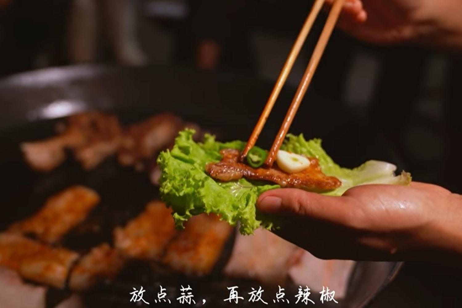 ภาพการห่อผักหรือซัมที่คล้ายกับการทานซัมเกาหลี