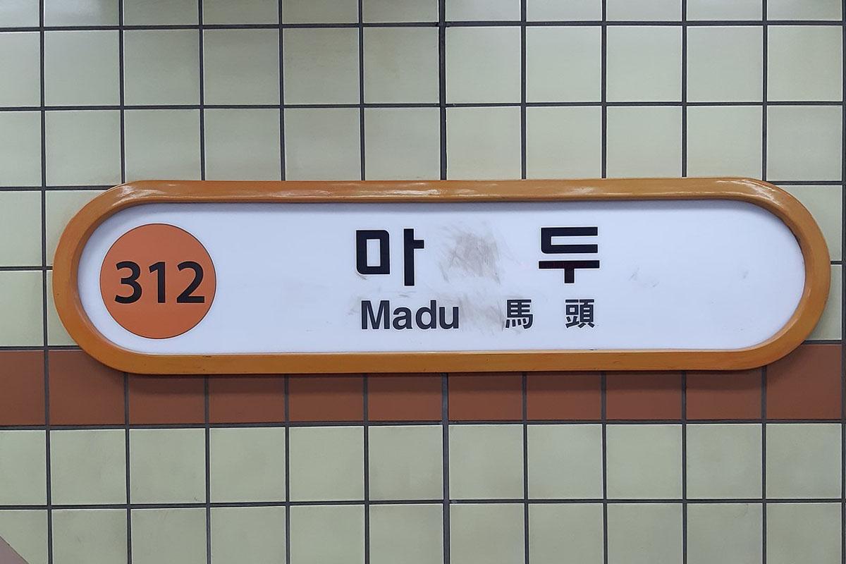 ป้ายสถานีมาดูในจังหวัดคยองกี เป็นที่รู้จักในฐานะสถานีปลายทางของรถไฟใต้ดินสาย 3 ที่ซึ่งชื่อสถานีแปลได้ว่า 'มาดู' ซึ่งฟังคล้ายภาษาไทย