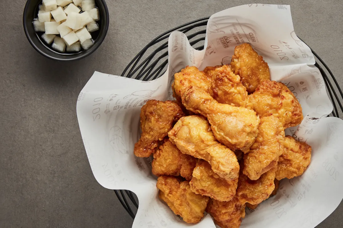 韩式炸鸡，金黄色酥脆炸鸡块，配以腌制的白萝卜。