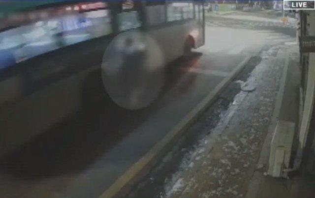 夜のバス停に停車中の市内バスの監視カメラ映像、左側にバスが見える。