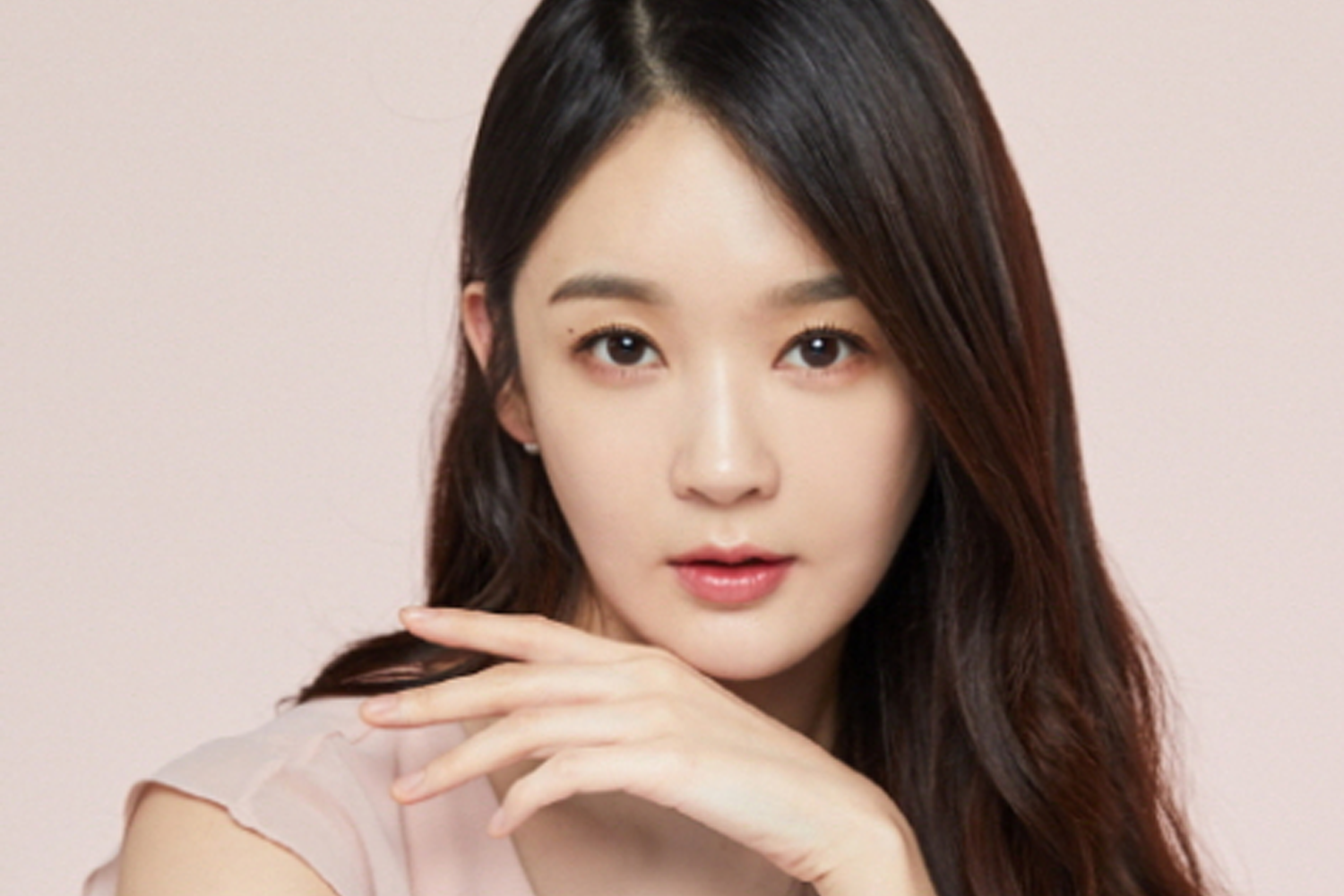 Davichi 成員 姜珉炅 身穿淡粉色的衣服，手輕搭在臉頰上，展現出温柔的氣質。「Creatrip」提供