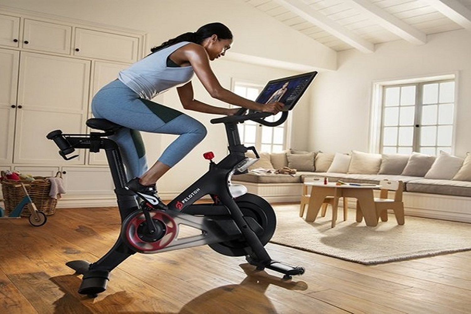 室內健身單車運動，一位女性在居家環境中使用智能單車訓練，增強腿部耐力和肌肉。