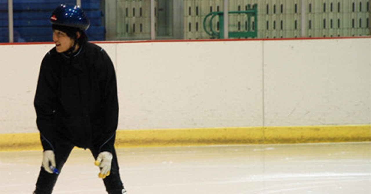 一位選手在冰上進行短道速滑訓練，這項運動需要高度的專注力和平衡力。
