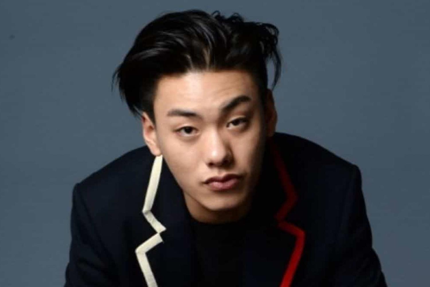 ชายคนหนึ่งสวมสูทสีดำในภาพถ่ายโปรไฟล์อย่างเป็นทางการ