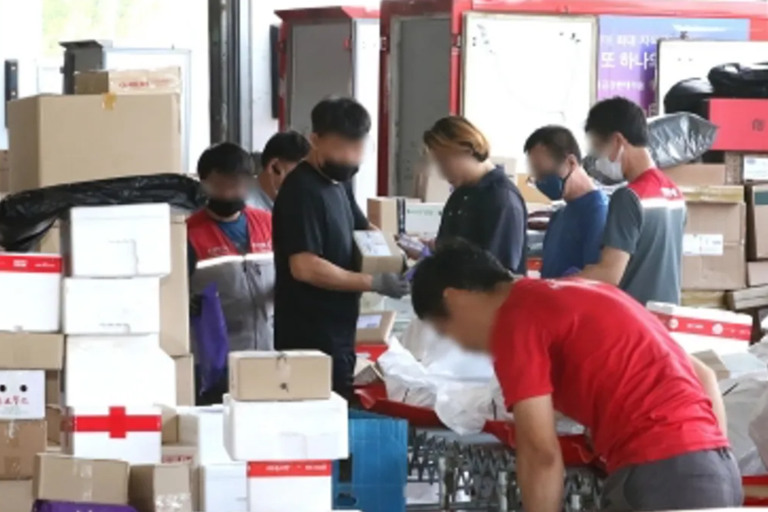 韩国快递司机团队在配送中心协作处理包裹。来源：뉴스1