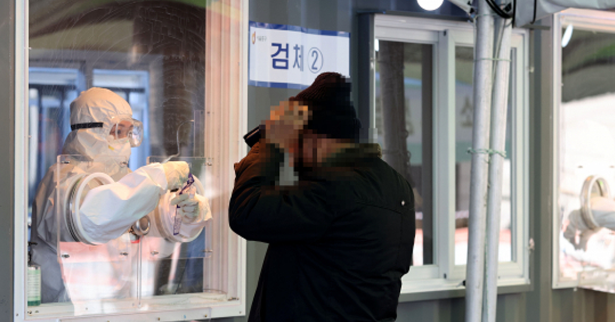 COVID-19檢測站中，工作人員穿著防護衣進行鼻咽拭子採樣以檢測新冠病毒。