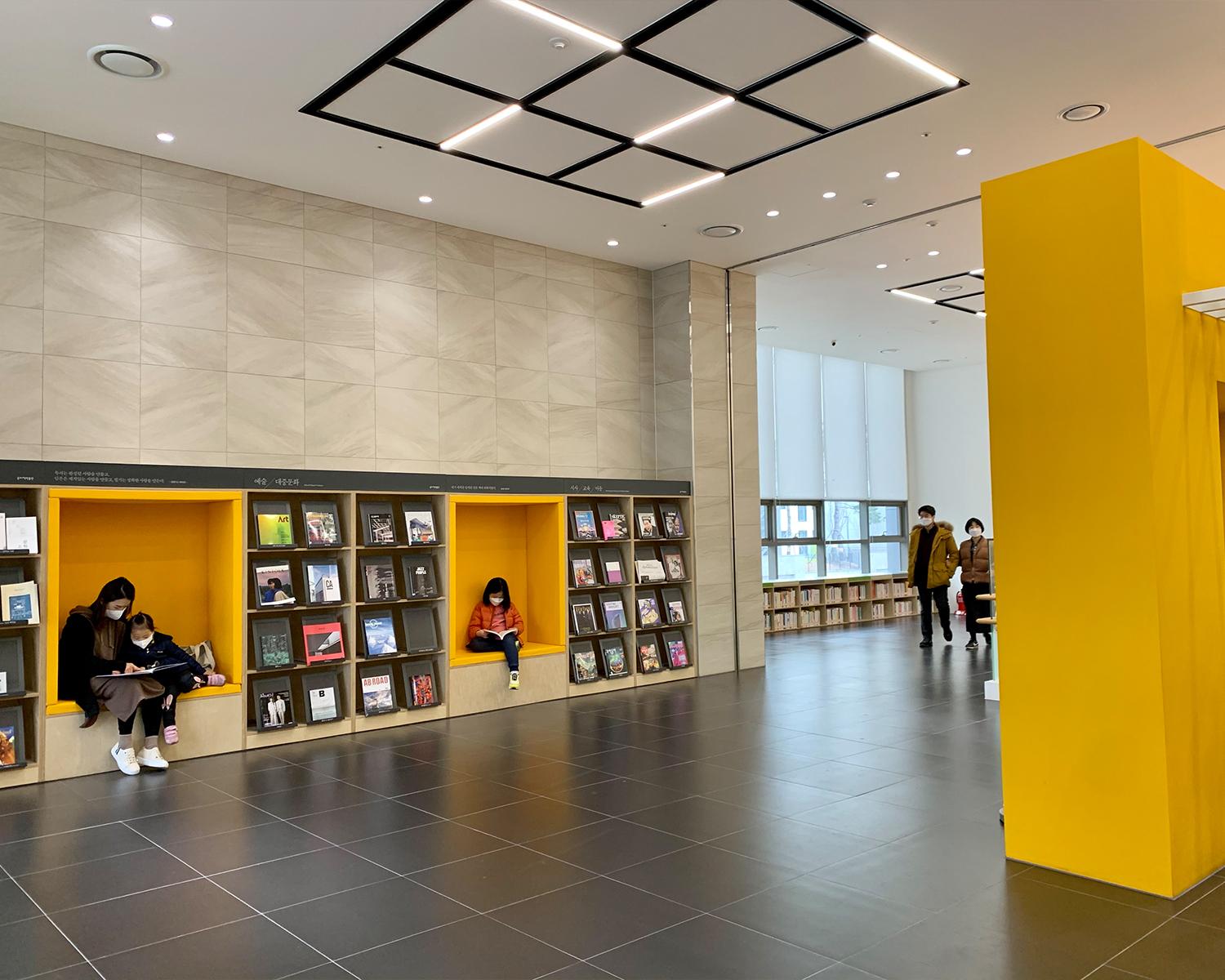 wooden bookshelves with yellow seats built in between at songpa book museum