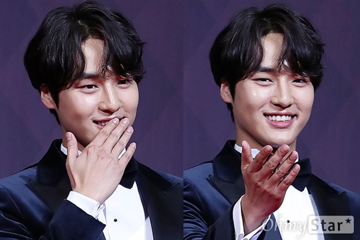 一名韓國男演員在正式場閤中做出飛吻手勢，顯得不太自然。