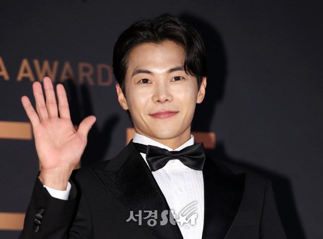 韓国の俳優、パク・ウンソクがタキシードを着て、手を振っている姿。