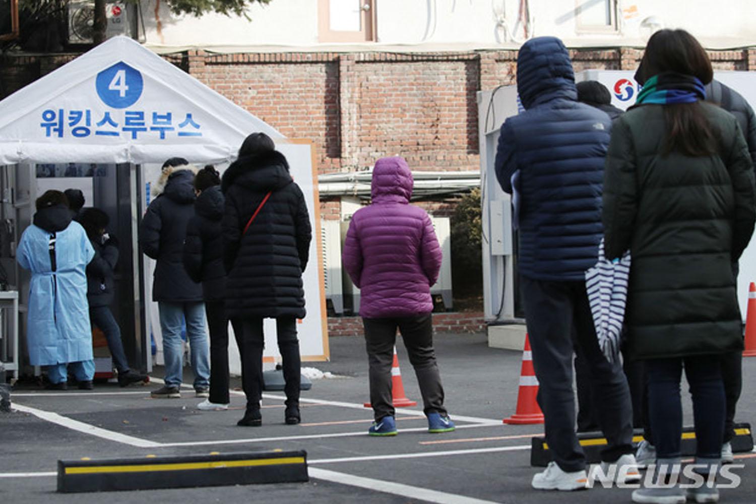 ประชาชนต่อแถวรอรับการตรวจ COVID-19 ที่ศูนย์ทดสอบในเกาหลีใต้ ภายใต้การรักษาระยะห่างทางสังคม