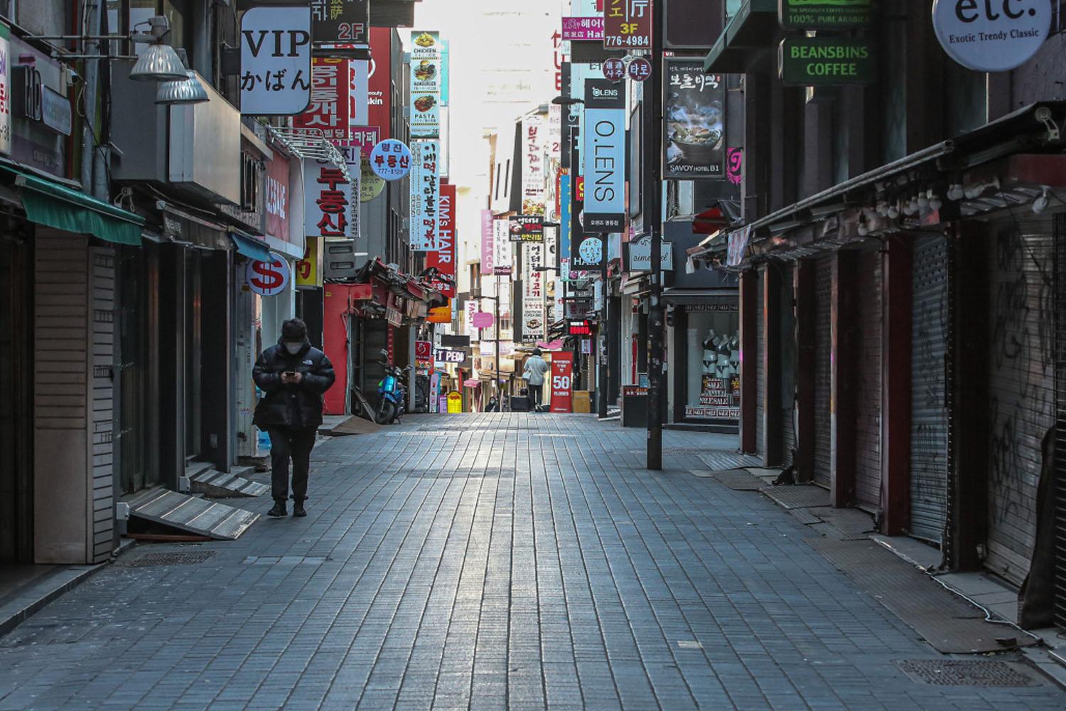 ถนนฮงแดในกรุงโซล เกาหลีใต้ เงียบสงบในช่วงมาตรการเคอร์ฟิวช่วง COVID-19 มีคนเดินอยู่เล็กน้อย ร้านค้าส่วนใหญ่ปิดทำการ