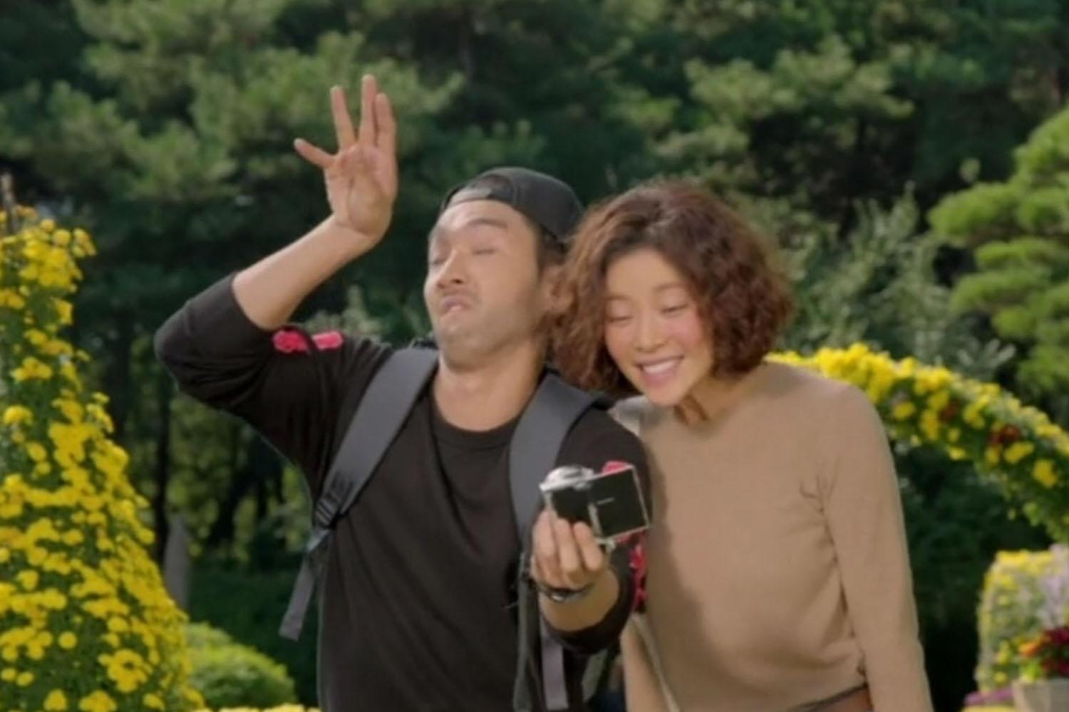 ฉากจากซีรีส์เกาหลีที่มีตัวละครสองคนอยู่ในสวนพฤกษา กำลังถ่ายภาพเซลฟี่ด้วยกัน เพื่อเก็บความทรงจำไว้ในวันภาพถ่าย (Photo Day) หรือวันที่ 14 กันยายนในเกาหลี