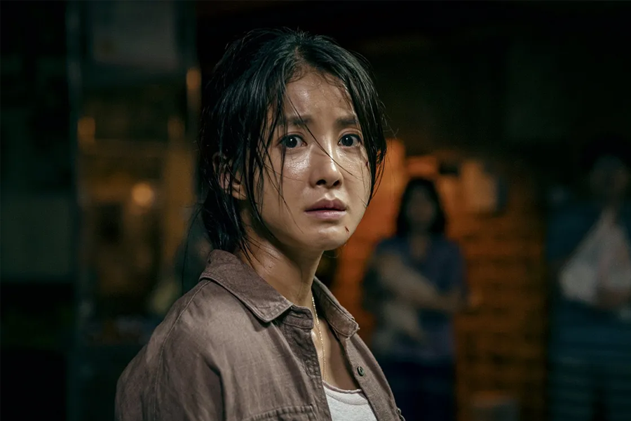 韓國電視劇《Sweet Home》中一位角色在昏暗的室內環境中,場景暗示著危險情況和角色的警惕心,來自Netflix的圖片。