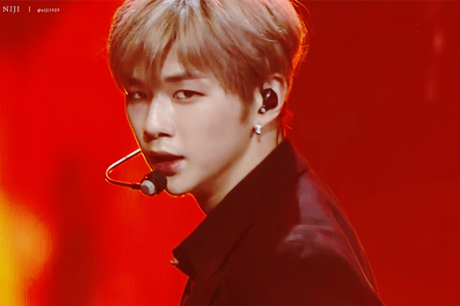 姜丹尼爾 在舞台上穿著紅色服裝，背景紅燈明亮。