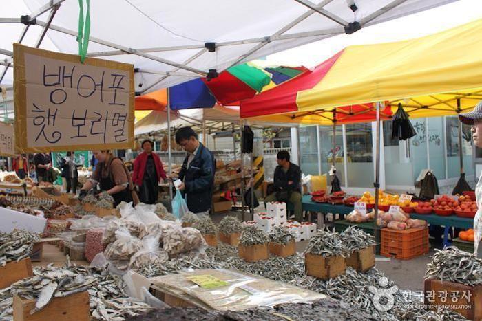 Stalls displaying dried seafood and local produce at a Korean 5-day market, illustrating the variety of goods available.