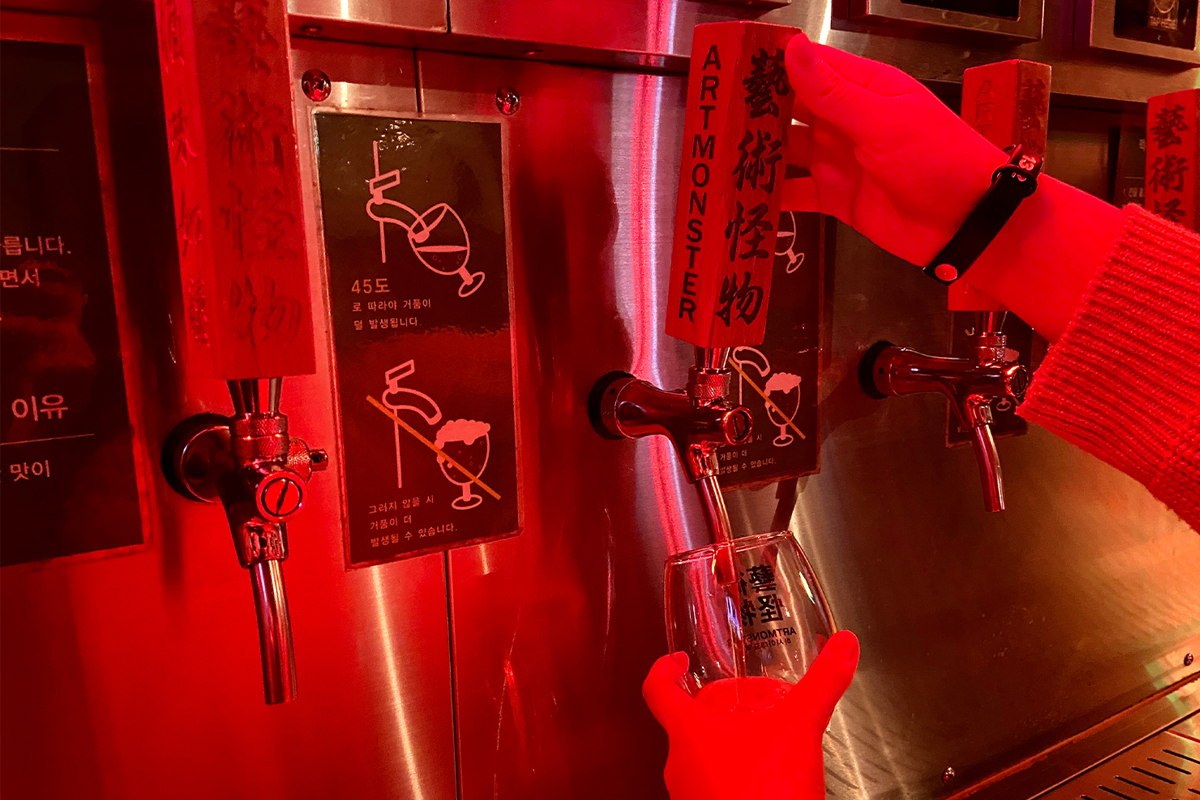 一位顧客正在從藝術怪物啤酒牆上倒酒