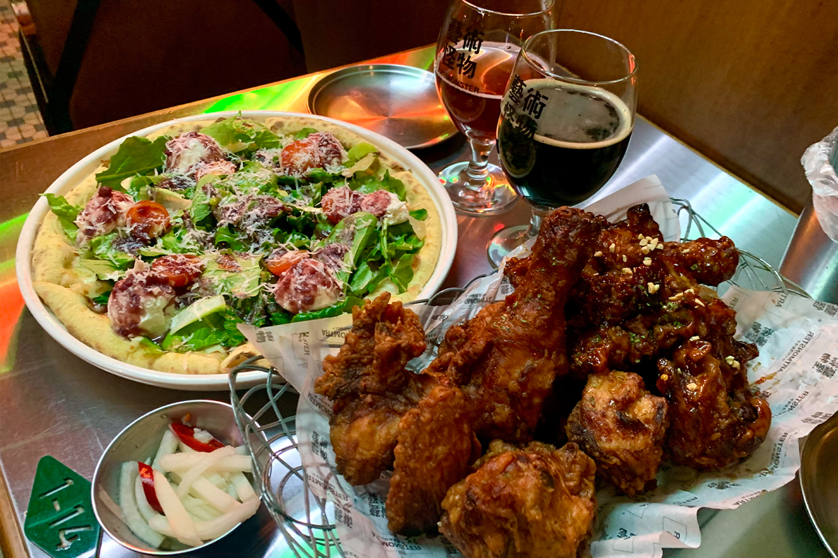 披薩和炸雞與啤酒搭配的桌上擺設