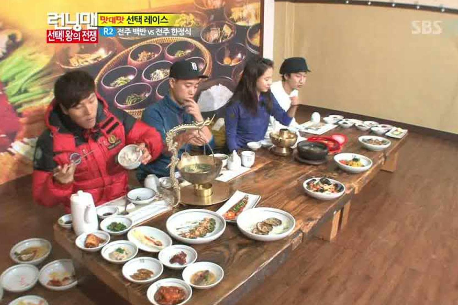 กลุ่มคนกำลังนั่งรับประทานอาหารเกาหลีพื้นเมืองบนพื้นแบบดั้งเดิมในร้านอาหารที่ประเทศเกาหลีใต้